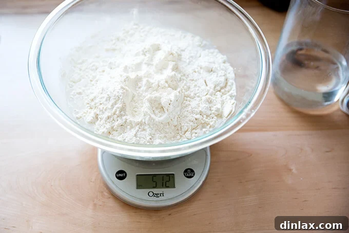 Adding 512 grams of bread flour to the wet ingredients.