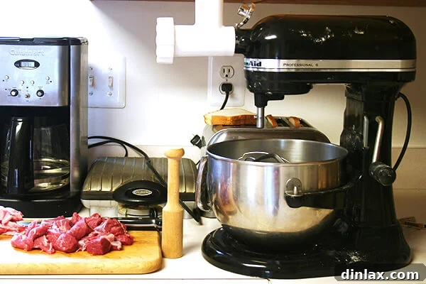 Meat grinder attachment on a stand mixer A stand mixer equipped with a meat grinder attachment, preparing to grind lamb.