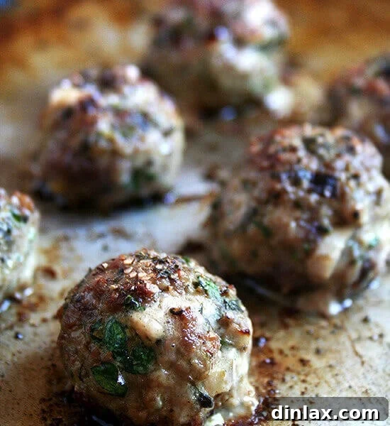 A sheet pan of broiled lamb meatballs.