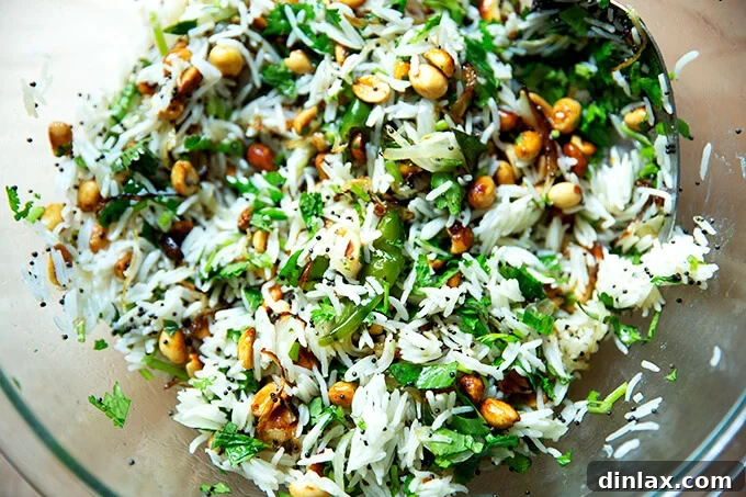 A close-up of the Indian Fried Rice, perfectly tossed to combine all ingredients, with individual grains, peanuts, and chilies visible.