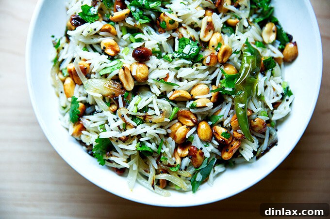 A wide shot of a delicious bowl of Indian fried rice, garnished with fresh cilantro and crunchy peanuts, against a rustic backdrop.