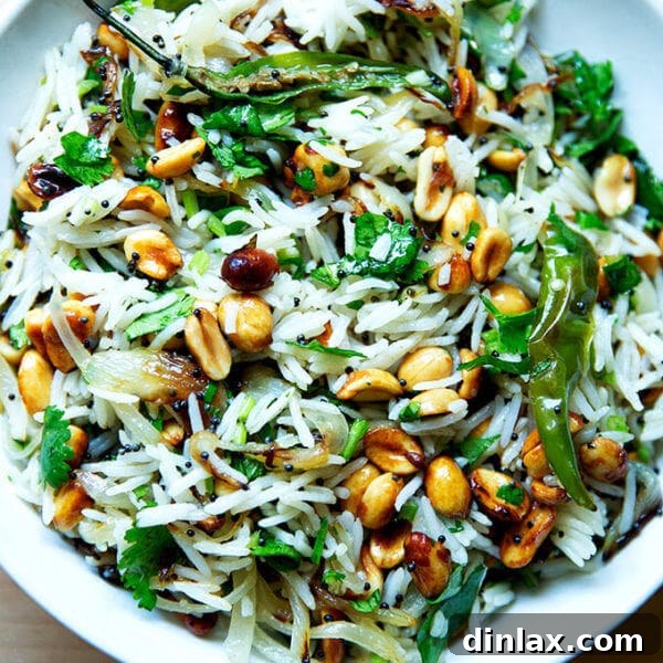 A bowl of Indian fried rice with peanuts and chilies.