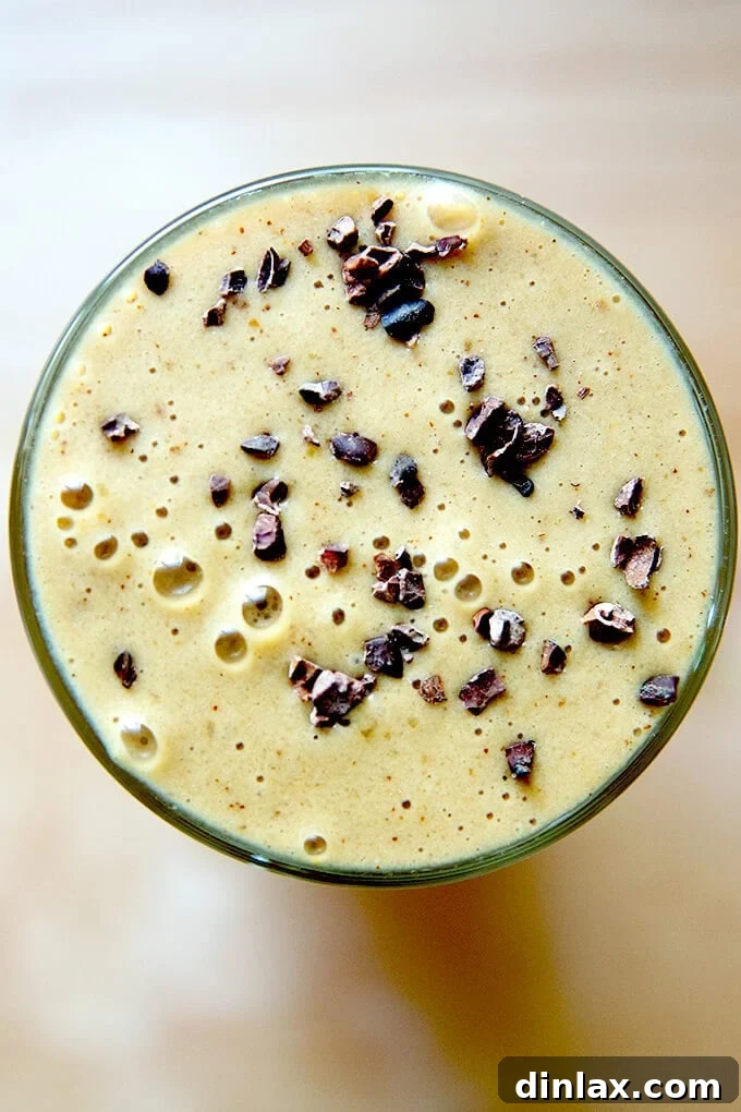 Mocha Date Banana Bliss Smoothie 2 A vibrant glass filled with a wholesome coffee smoothie, featuring dates, banana, hidden cauliflower, creamy almond milk, almond butter, and a sprinkle of cacao nibs.