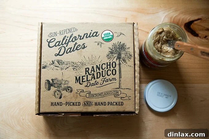 A box of premium Rancho Meladuco Dates alongside a jar of creamy almond butter.
