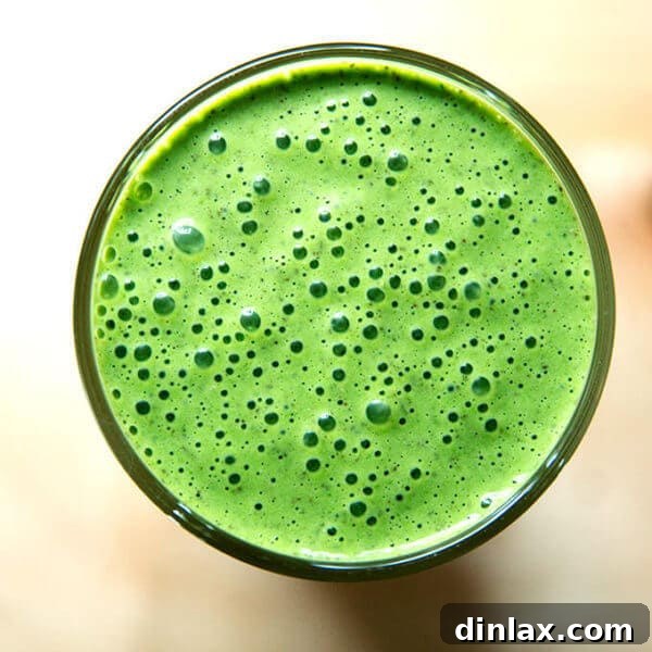 Overhead shot of vegan green smoothie with almond milk, banana, and spinach.