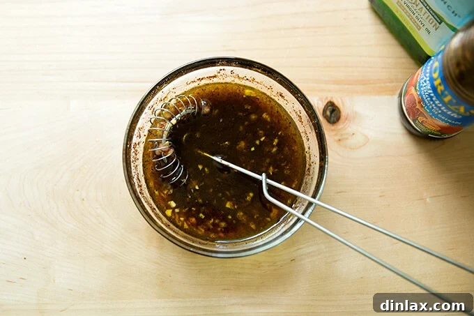 Vibrant Spring Fattoush 8 A bowl filled with freshly prepared Fattoush salad dressing, with a whisk resting inside, indicating its readiness to be tossed with the salad.