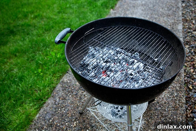 A Weber grill showcasing glowing, white-hot coals strategically pushed to one side, creating both hot and cooler cooking zones for versatile grilling.