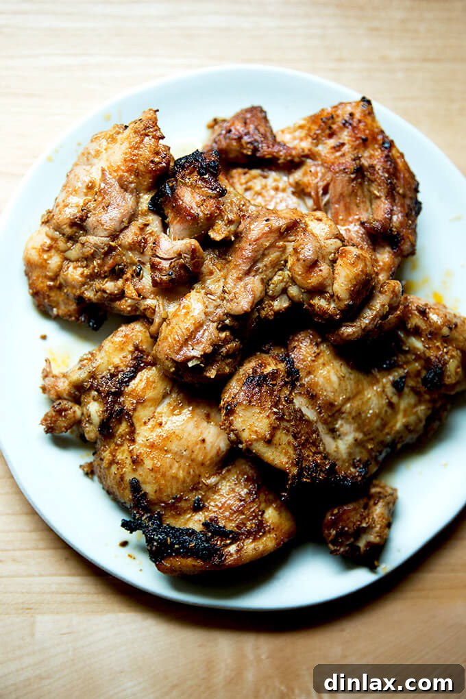 Perfectly smoky grilled chicken thighs resting on a platter, allowing the juices to redistribute for maximum tenderness and flavor before serving.