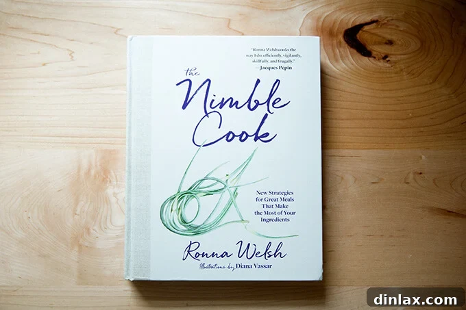A copy of 'The Nimble Cook' cookbook rests on a kitchen counter.