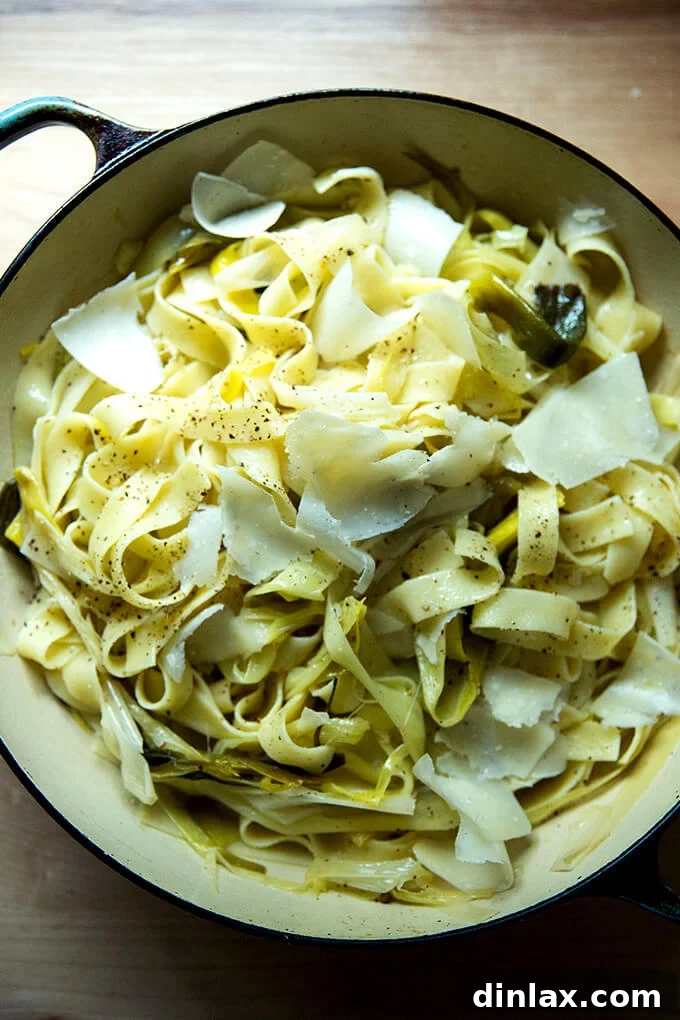 The braising pan now holds the braised leeks and pappardelle, beautifully adorned with generous shavings of Parmesan cheese.