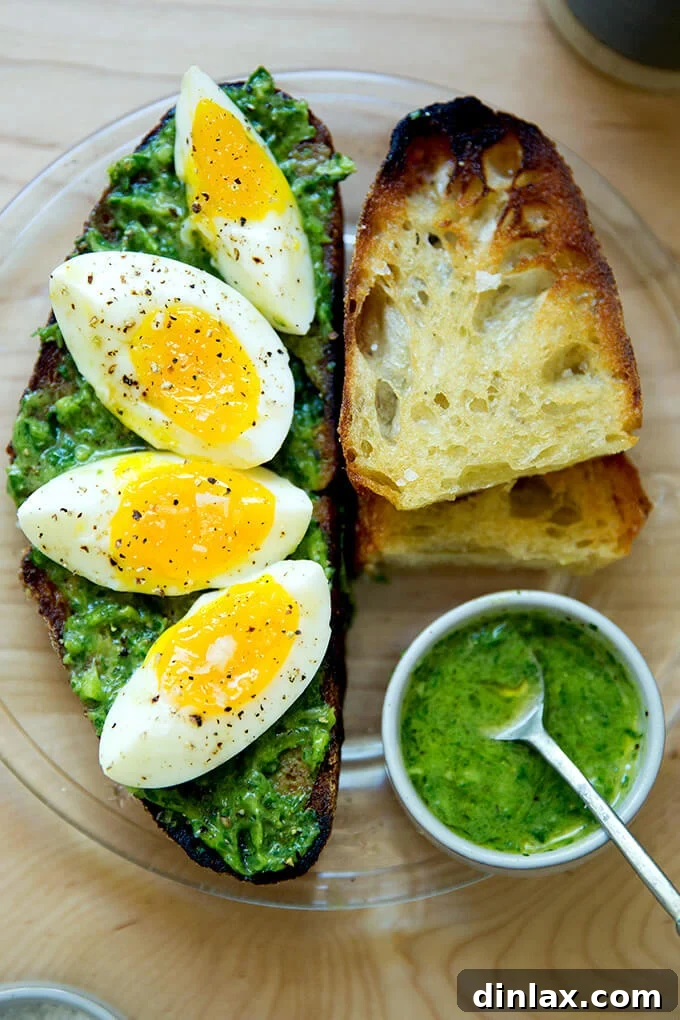 The Ultimate Herby Avocado Green Sauce 6 A beautifully presented plate of toasted sourdough with green sauce and two halved 7-minute eggs.