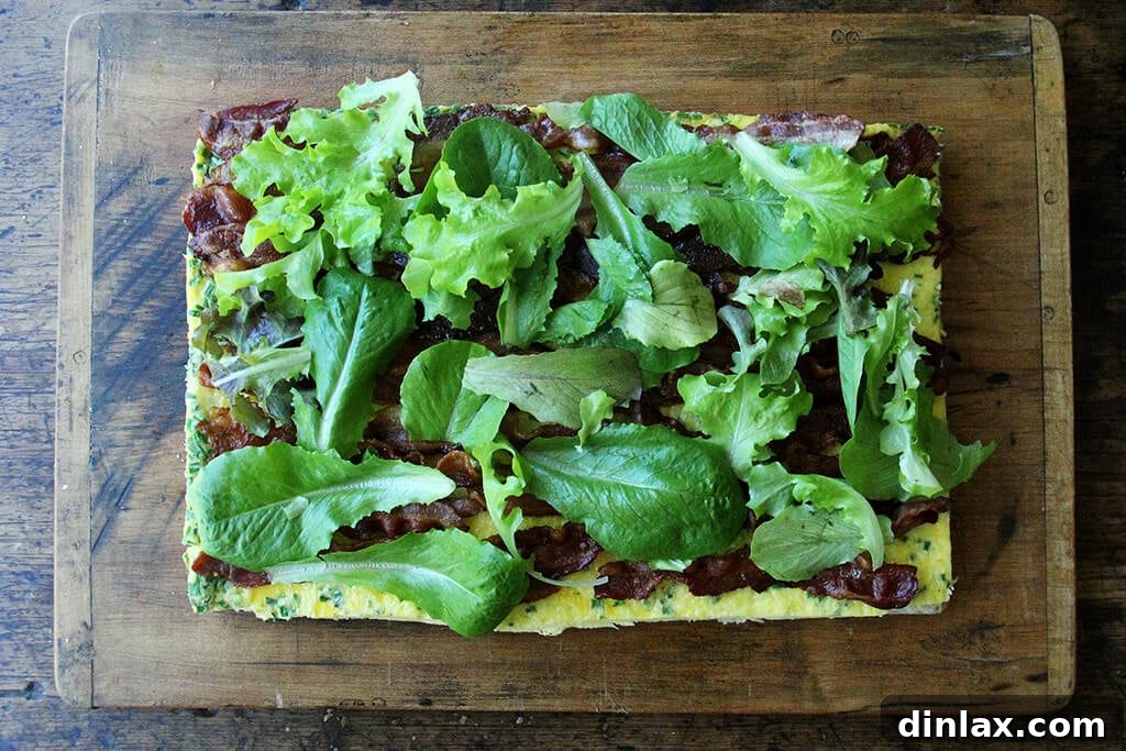 Ultimate Sheet Pan Breakfast Slab Sandwich: Bacon, Egg, and Cheese 13 A cutting board with the sheet pan breakfast sandwich being assembled.