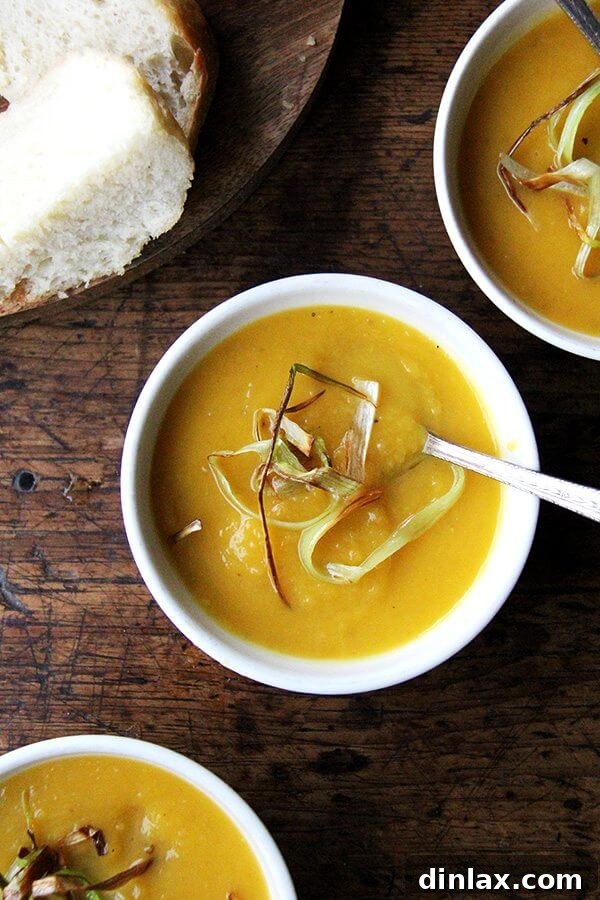Warm, inviting slow-cooker butternut squash and apple soup served in bowls, garnished with a swirl of cream and fresh herbs, perfect for a cozy meal.