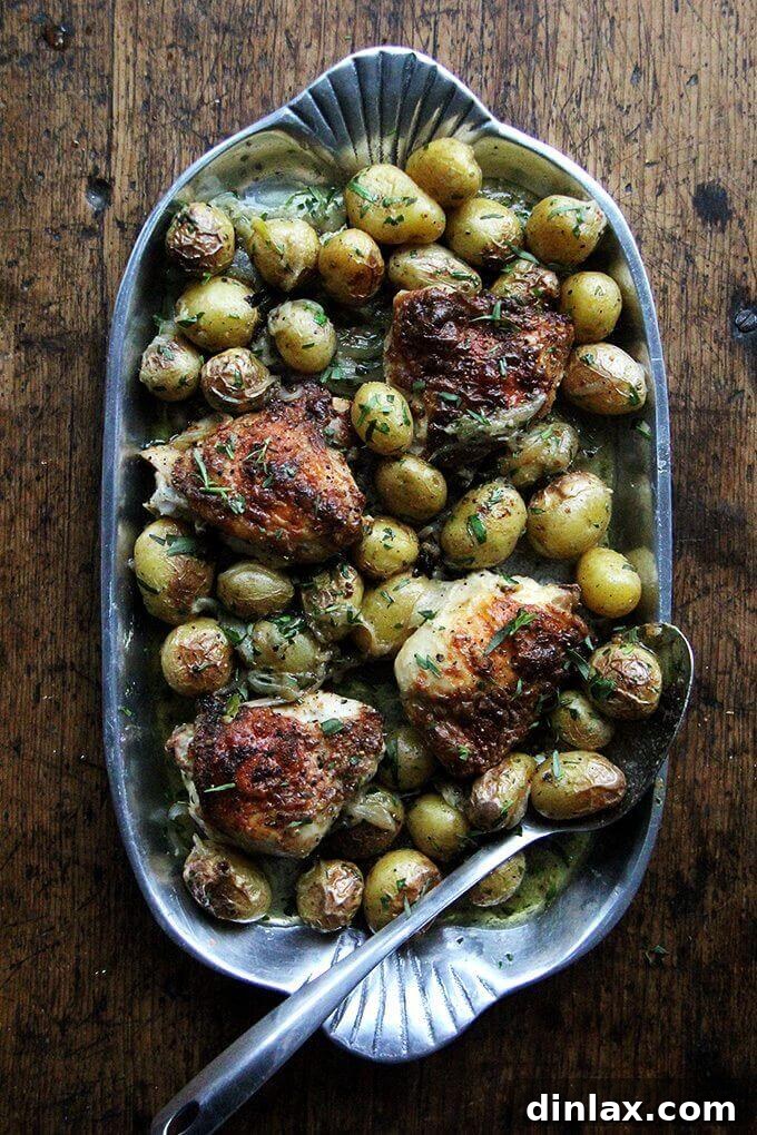 Crispy, golden-brown one-pan chicken pieces nestled among tender, herb-roasted potatoes with fresh tarragon, highlighting a simple yet flavorful family meal.