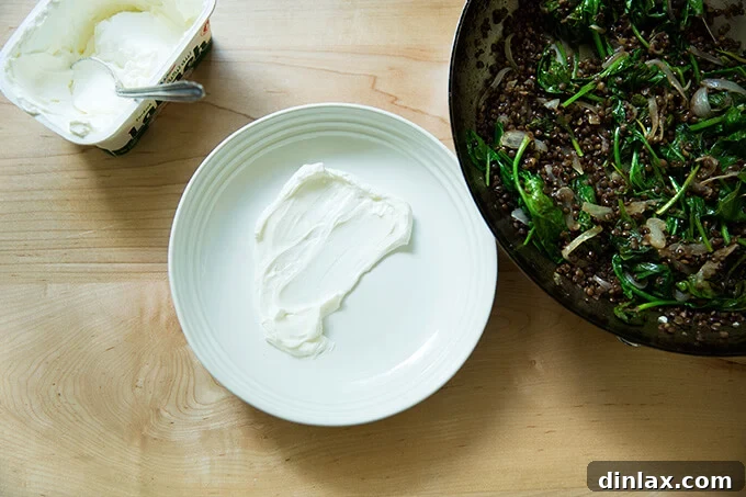 Irresistible Black Lentil and Spinach Delight 12 A plate with a creamy smear of labneh, forming the base for the lentil dish.