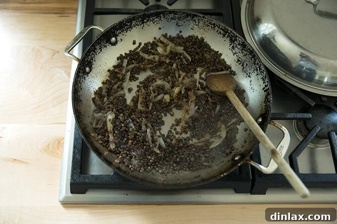 Irresistible Black Lentil and Spinach Delight 8 A skillet showing cooked lentils mixed thoroughly with the caramelized onions.