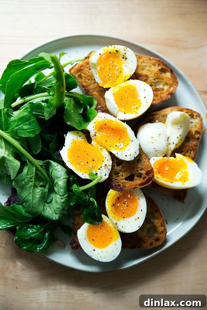 Jammy Eggs & Tangy Olive Oil Toast 2 A plate of vinaigrette toasts topped with soft-boiled eggs aside dressed arugula.