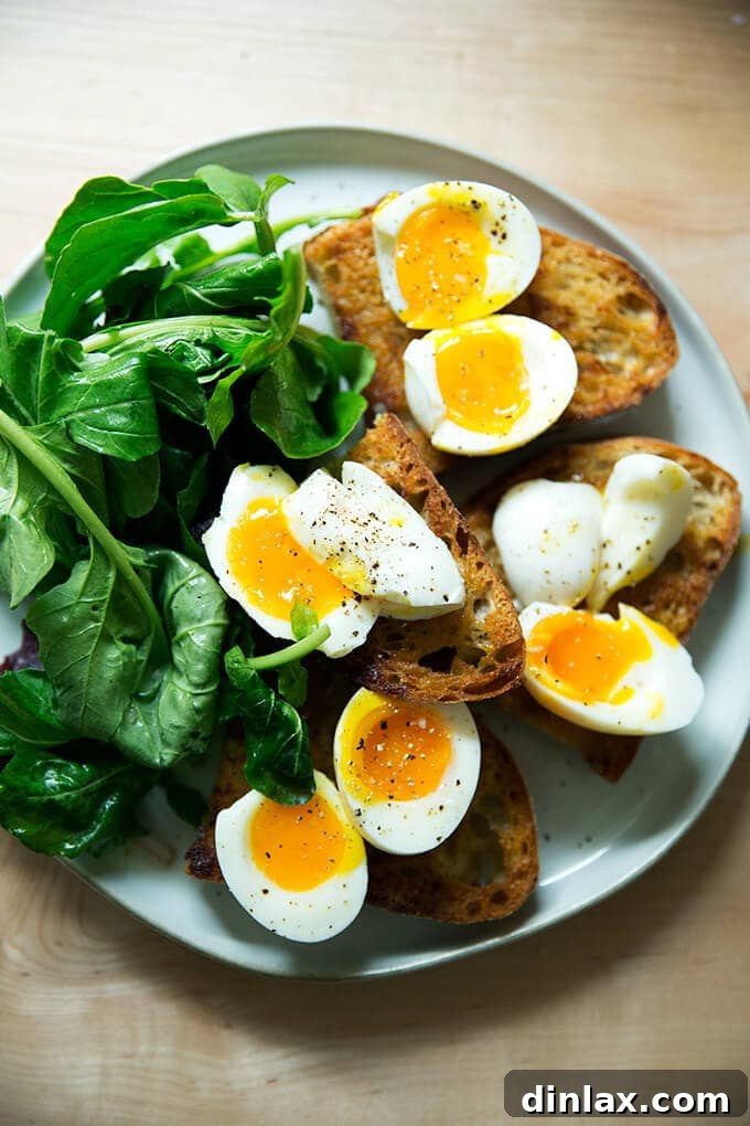 Jammy Eggs & Tangy Olive Oil Toast 11 A plate of vinaigrette toasts topped with soft-boiled eggs aside dressed arugula.