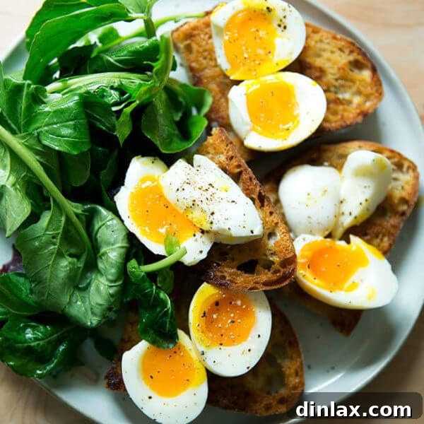 A plate of vinaigrette toasts topped with soft-boiled eggs aside dressed arugula.