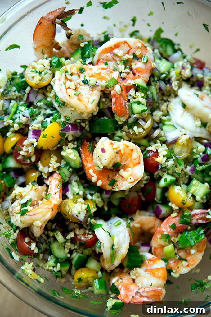 A beautifully presented bowl of Tabbouleh with cilantro, lime, and grilled shrimp, ready to be enjoyed.