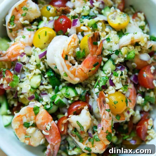 A bowl of tabbouleh with cilantro, lime, and grilled shrimp.