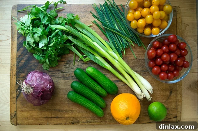 A cutting board laden with fresh, colorful vegetables and herbs, prepped for tabbouleh.