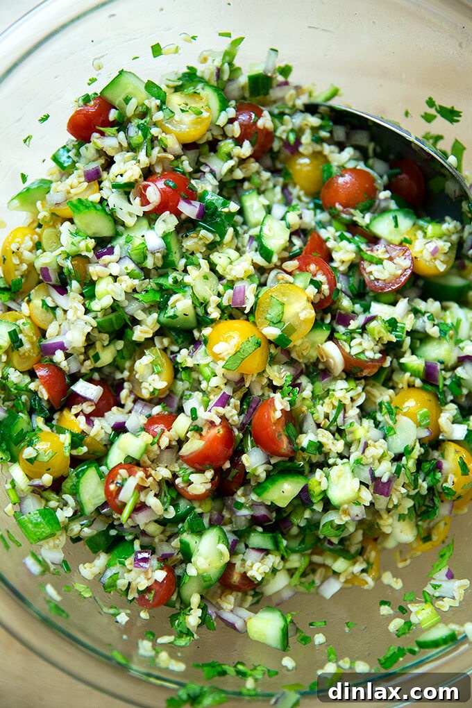 A large bowl filled with vibrant tabbouleh salad, perfectly tossed with bulgur, vegetables, and dressing.