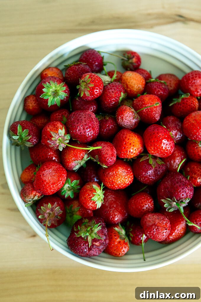 Refreshing Strawberry Sorbet Nestled in Buttery Almond Butterscotch Cookie Cups 3 Freshly hulled strawberries in a bowl, ready for sorbet preparation.