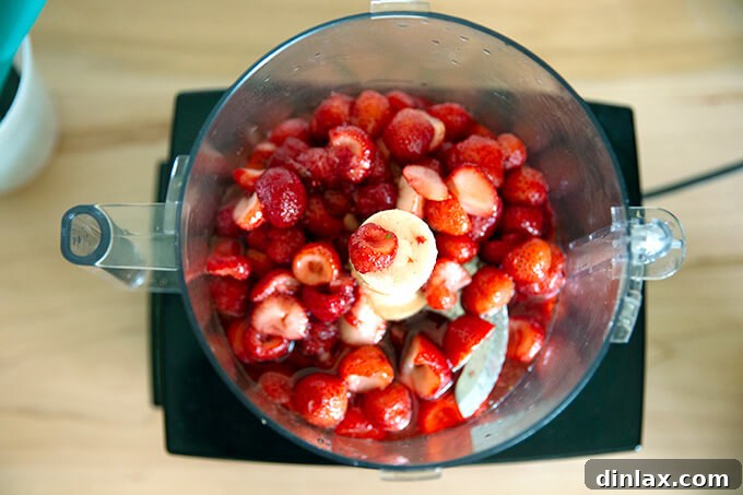 Refreshing Strawberry Sorbet Nestled in Buttery Almond Butterscotch Cookie Cups 7 Strawberry mixture being poured into a food processor for blending.