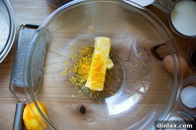 A bowl with a stick of softened butter and fresh lemon zest mixed in it.