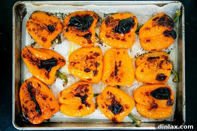 Hearty Harvest Stuffed Bell Peppers 11 A baking sheet holding perfectly blistered orange bell peppers, freshly removed from the oven and glistening, ready for the next step of filling.