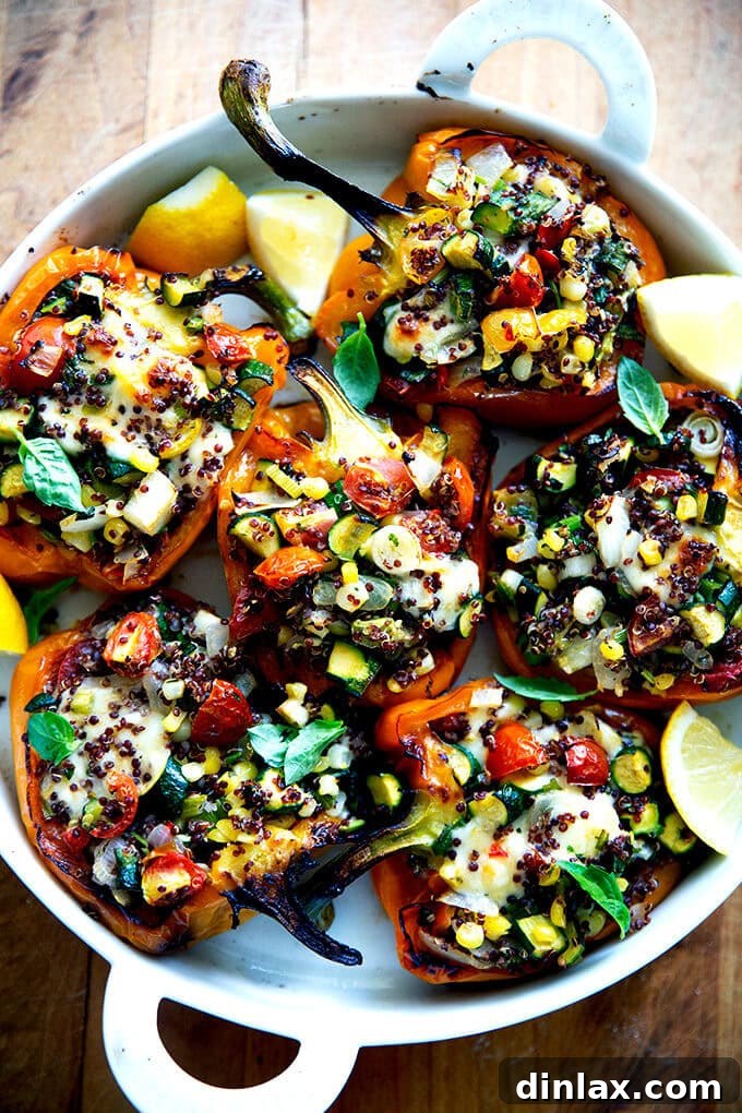 Hearty Harvest Stuffed Bell Peppers 15 A close-up shot of a perfectly baked, veggie-loaded stuffed bell pepper, featuring a golden-brown top of melted cheese over a colorful filling of quinoa, sweet corn, tender zucchini, and juicy tomatoes, garnished with fresh herbs.