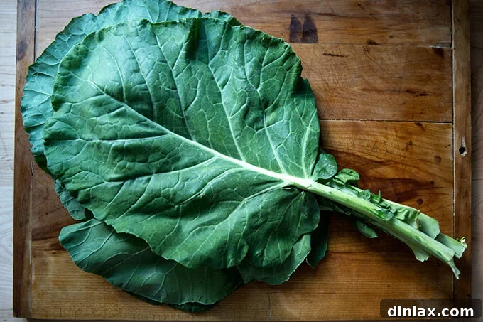 A fresh, vibrant bunch of collard greens resting on a wooden cutting board, ready for preparation.