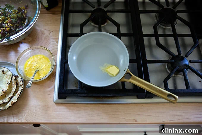 A nonstick sauté pan with a small dab of butter melting, ready for cooking.