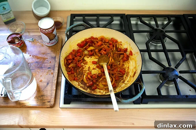 A board with sautéed onions, spices and tomatoes.