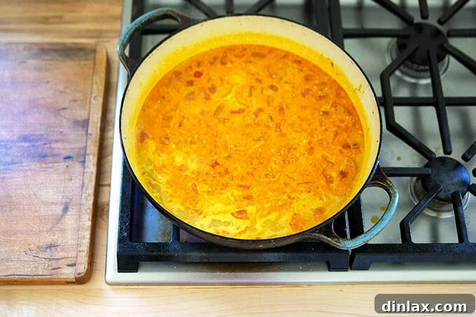 Curry sauce simmering in a large sauté pan