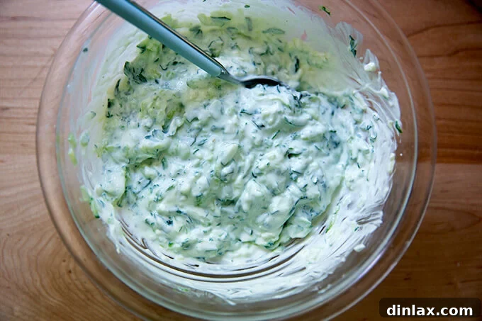 A serving bowl filled with freshly prepared tzatziki, showing its creamy texture and green flecks of herbs.