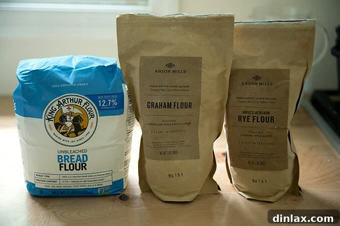 Simple Sourdough with a Hearty Whole Grain Touch 8 Three types of flour arranged on a countertop: King Arthur Flour bread flour, Anson Mills Graham Flour, and Anson Mills Rye flour.