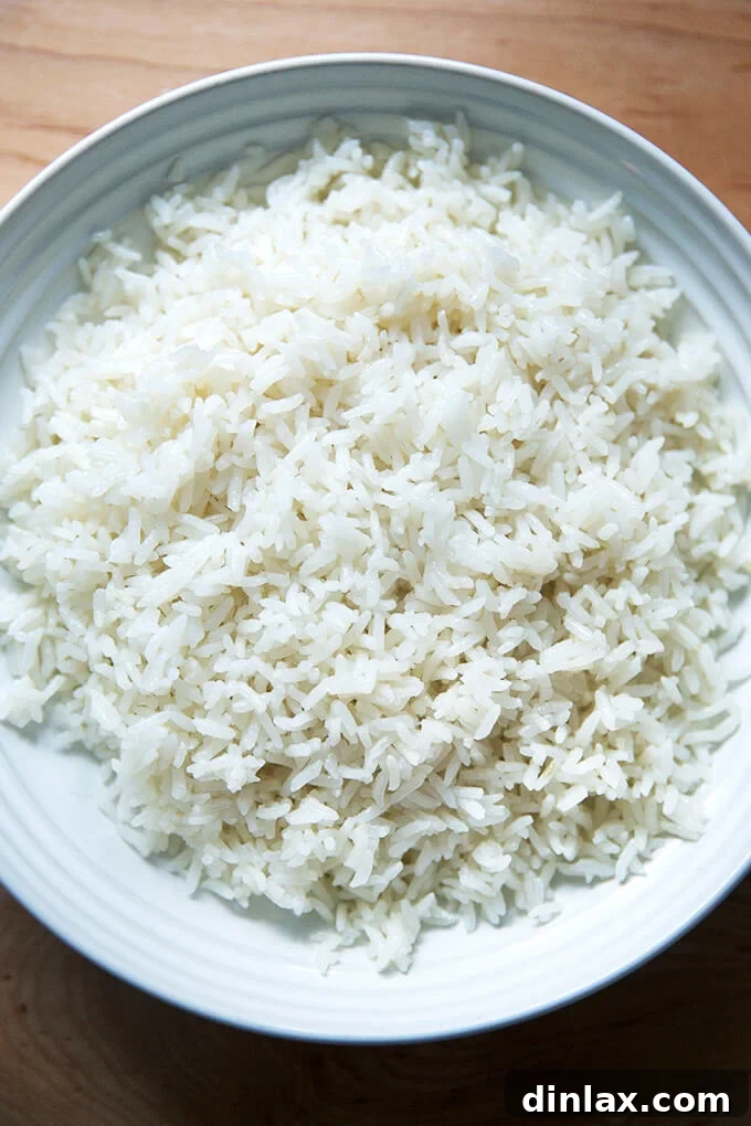 A beautifully fluffed bowl of perfectly cooked coconut rice, garnished with a sprinkle of fresh cilantro, ready to be served.