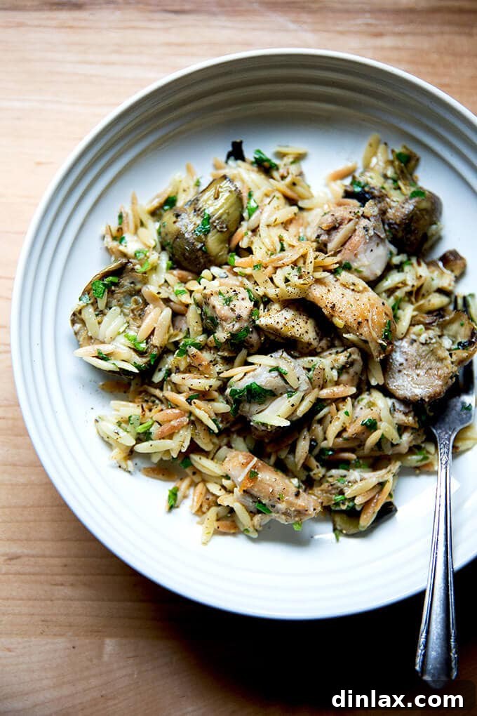 Zesty Lemon Artichoke Orzo Chicken Skillet 2 Golden brown chicken thighs searing in a skillet, key for a one-pan lemon orzo dish.