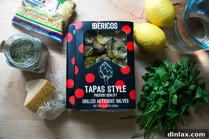 Zesty Lemon Artichoke Orzo Chicken Skillet 4 A selection of fresh ingredients including chicken thighs, lemon, parsley, artichoke hearts, and orzo, ready for cooking.