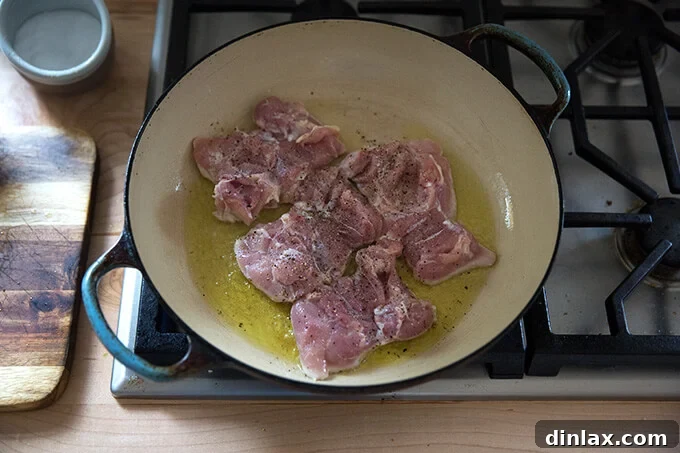 Zesty Lemon Artichoke Orzo Chicken Skillet 6 Four boneless, skinless chicken thighs browning in olive oil in a hot skillet.