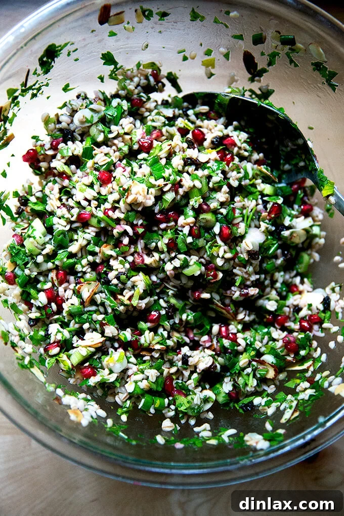 An overhead shot of a large glass bowl filled with vibrant green winter tabbouleh, perfectly dressed and mixed.