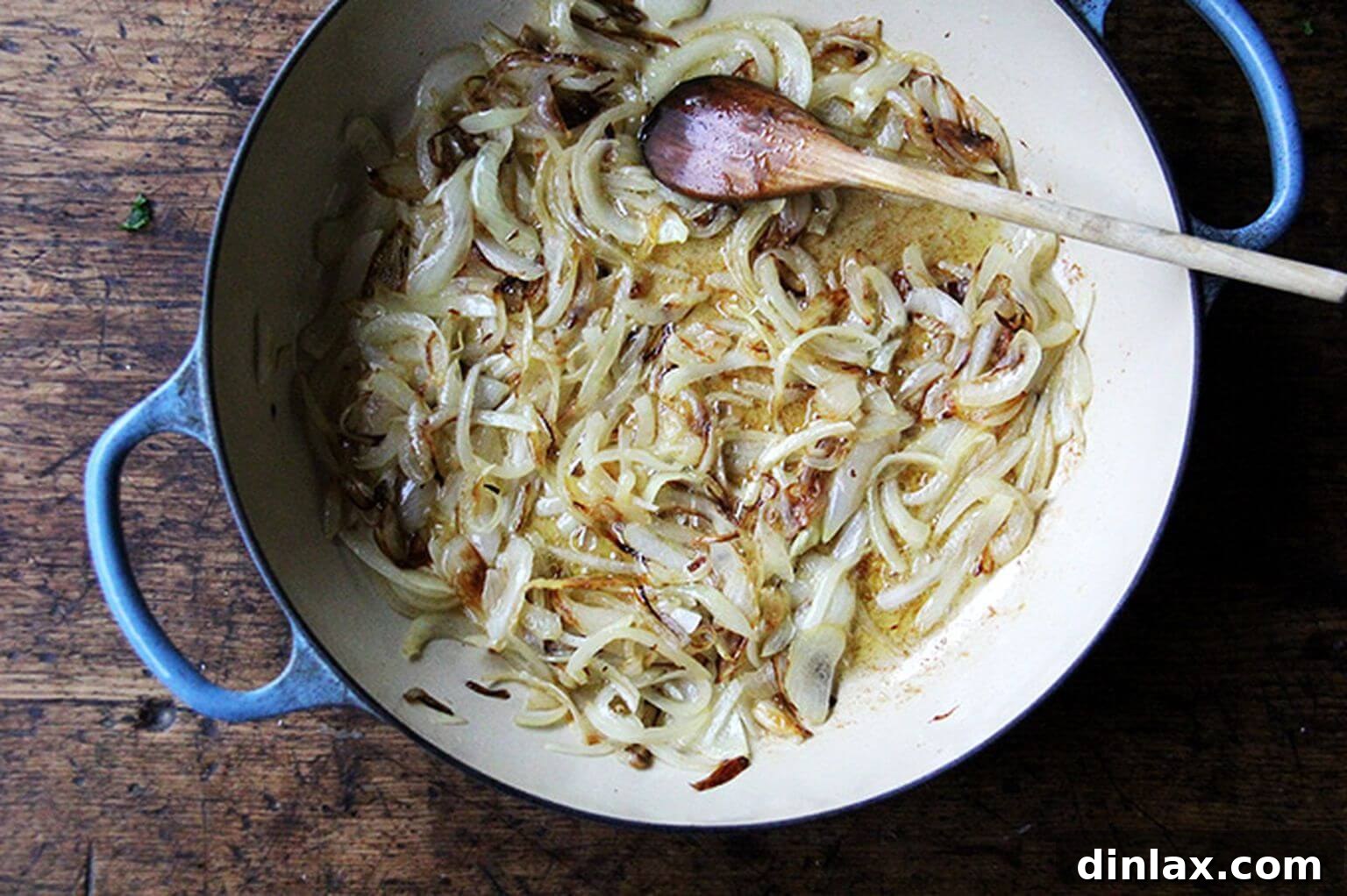 A large sauté pan brimming with richly caramelized onions, boasting a deep golden-brown hue and sweet aroma.