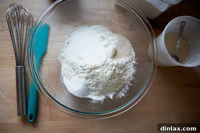 An overhead shot of a glass bowl with the precisely measured dry ingredients for the buttermilk pull-apart rolls, ready for mixing.