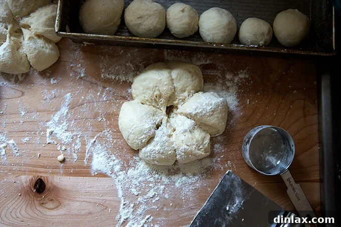 Buttermilk pull-apart dough meticulously divided into small, even portions on a floured surface.