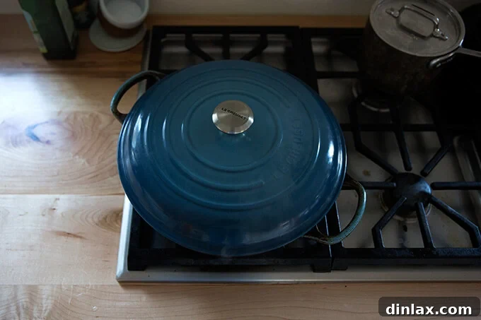 Japchae: Vegetarian Korean Glass Noodles 13 A covered Le Creuset braiser positioned on the stovetop, heat turned to medium-high, as the japchae cooks inside.