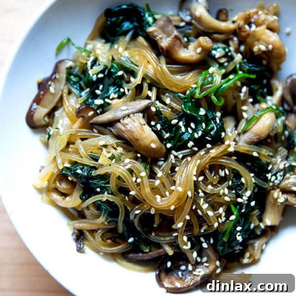 A vibrant bowl of freshly prepared japchae, showcasing its glossy noodles and colorful vegetables.
