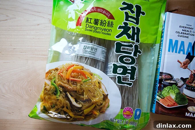 Japchae: Vegetarian Korean Glass Noodles 3 A neatly packaged bag of dangmyeon, Korean sweet potato noodles, resting on a clean kitchen counter, ready for preparation.