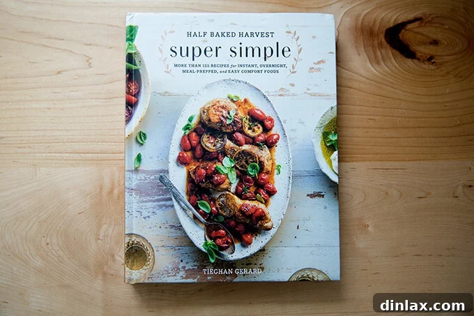 A cookbook titled 'Half Baked Harvest Super Simple' open on a kitchen countertop, showcasing its inviting pages.